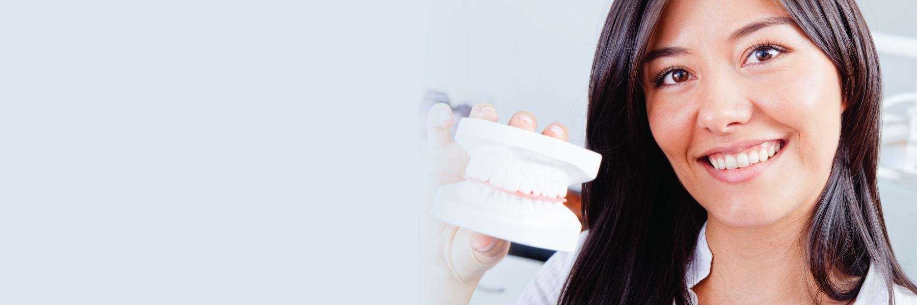 Lady holding a model of dental crown in Audubon, NJ